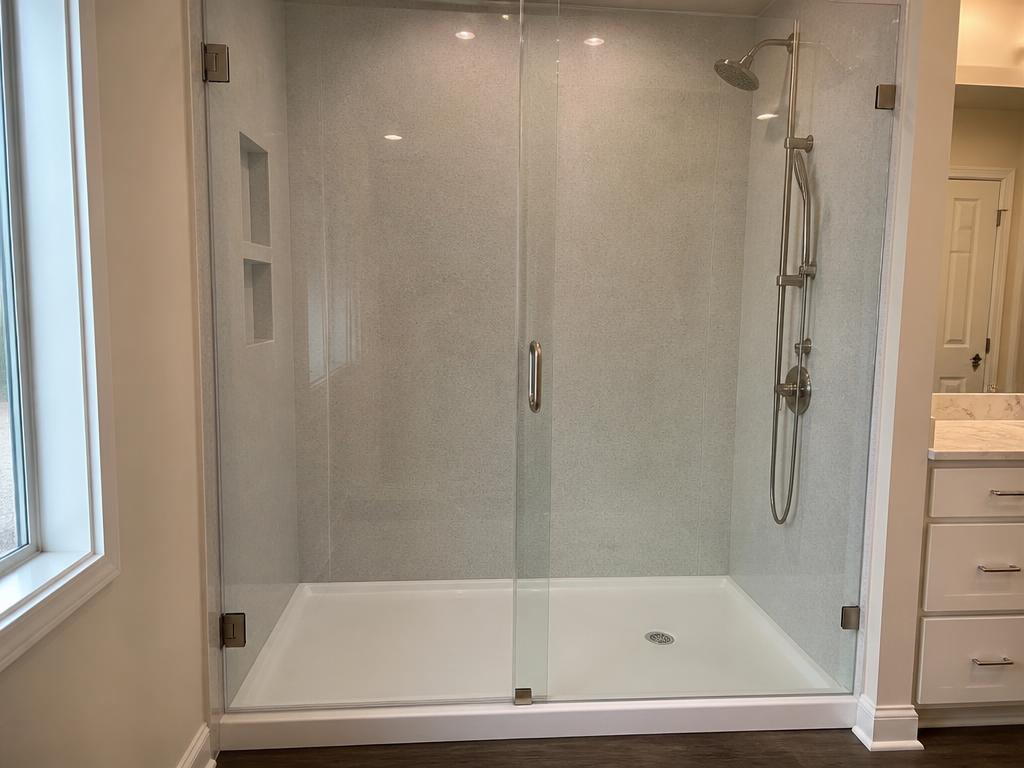 Walk-in shower remodel with frameless glass and marble-look walls
