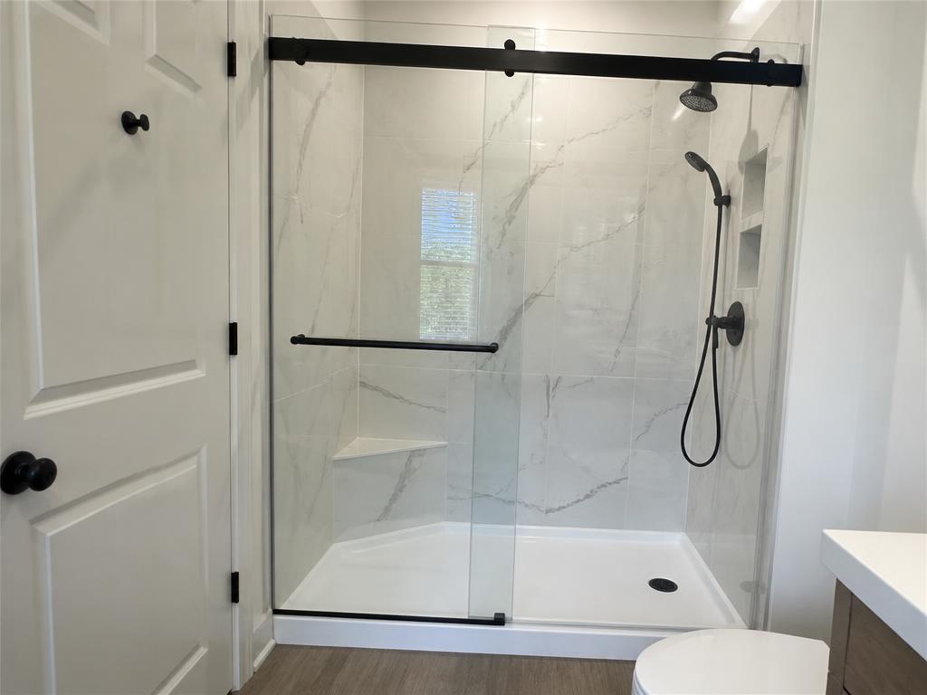 Low-threshold walk-in shower with safety grab bars